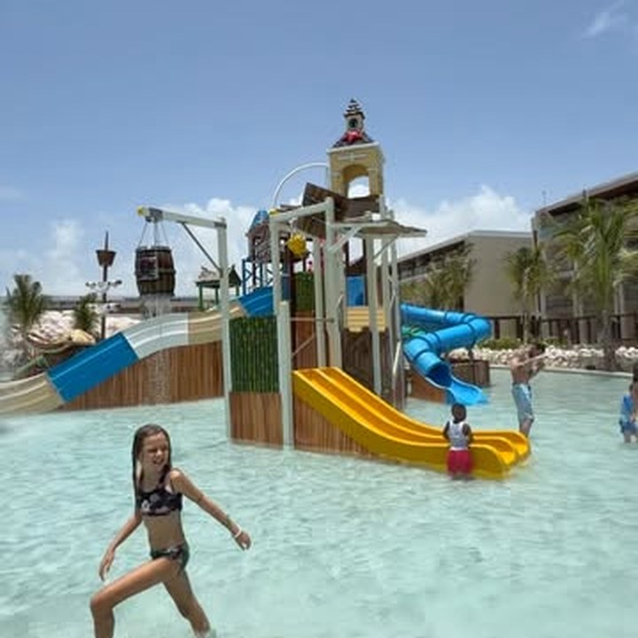Chicos divirtiéndose en el parque acuático de un resort all inclusive